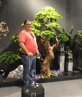 Man standing next to artificial tree